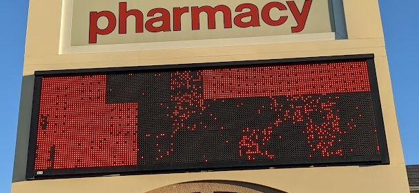Photo of an outdoor CVS pharmacy electronic message sign that has malfunctioned and displays a nonsense pattern of lights.
